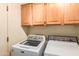 Bright laundry room featuring a newer washing machine, dryer and ample storage space in overhead cabinets at 10901 E Sunnydale Dr, Sun Lakes, AZ 85248