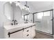 Modern bathroom with double sinks, a decorative light fixture, and walk-in shower at 1119 W Heather Ave, Gilbert, AZ 85233