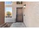 Inviting front door with a textured stucco wall, brick accents, and metal security door at 1119 W Heather Ave, Gilbert, AZ 85233