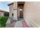 Inviting front entrance with a textured stucco wall, brick accents, and metal security door at 1119 W Heather Ave, Gilbert, AZ 85233