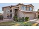 Two-story stucco home showcasing a well-manicured lawn, desert landscaping, and an attached two-car garage at 1119 W Heather Ave, Gilbert, AZ 85233