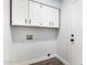 This laundry room features white cabinets, an outlet and dark floors at 1119 W Heather Ave, Gilbert, AZ 85233