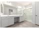 Bright bathroom featuring double sinks, white cabinetry and a glass enclosed shower at 11620 W Marguerite Ave, Avondale, AZ 85323