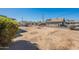 Large backyard featuring dirt landscaping, shed, block fence and mature shrubbery under a clear blue sky at 12010 N 113Th Ave, Youngtown, AZ 85363