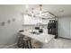 Modern kitchen features white cabinets, a quartz countertop island with seating, and stainless steel appliances at 12010 N 113Th Ave, Youngtown, AZ 85363