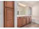 Bathroom featuring dual sinks, wood cabinets, and large mirror with vanity lighting at 12622 W Apodaca Dr, Litchfield Park, AZ 85340