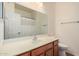 Well-lit bathroom featuring a large mirror and wood vanity, complemented by a neutral-toned shower curtain at 12622 W Apodaca Dr, Litchfield Park, AZ 85340