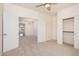 Light-filled bedroom with a ceiling fan, closet, and an open entry to another room at 12622 W Apodaca Dr, Litchfield Park, AZ 85340