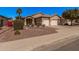 Inviting single-story home with desert landscaping, a palm tree, and a convenient two-car garage at 12622 W Apodaca Dr, Litchfield Park, AZ 85340