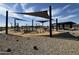 Community playground featuring shade canopies and a variety of play equipment on wood chip surface at 15665 W Deanne Dr, Waddell, AZ 85355