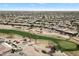 Aerial view of the golf course and neighborhood featuring lush green fairways and palm trees at 16769 W Brookhaven Ct, Surprise, AZ 85387