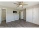 Spacious bedroom featuring a ceiling fan, hardwood floors, and an ensuite bathroom at 1715 E El Parque Dr, Tempe, AZ 85282