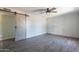 Bedroom featuring modern sliding barn door, painted brick wall and ceiling fan at 1715 E El Parque Dr, Tempe, AZ 85282