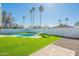 Palm tree lined backyard featuring an inviting pool, slide, and artificial grass at 1715 E El Parque Dr, Tempe, AZ 85282