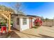 Well-maintained exterior with white siding, red door, and pergola, enhancing the home's curb appeal and outdoor living space at 17335 W Cheryl Dr, Waddell, AZ 85355