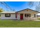 Beautiful home featuring a vibrant green lawn, white siding, and a welcoming red door at 17335 W Cheryl Dr, Waddell, AZ 85355