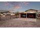 A dual-bay garage with a two parked vehicles, complete with overhead lighting and rustic charm at 17335 W Cheryl Dr, Waddell, AZ 85355