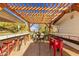 Outdoor pergola with built-in bar, grill, and seating area, creating an ideal space for entertaining and relaxation at 17335 W Cheryl Dr, Waddell, AZ 85355