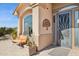 Inviting front porch with a decorative metal door, desert plants, and outdoor seating at 17366 E Via Del Oro St, Fountain Hills, AZ 85268