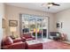 Cozy living room with leather chairs, a ceiling fan, and sliding glass doors to the outside at 17366 E Via Del Oro St, Fountain Hills, AZ 85268