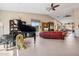 Open-concept living room with a grand piano, red leather sofa, vaulted ceilings, and fireplace at 17366 E Via Del Oro St, Fountain Hills, AZ 85268