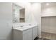 Bathroom with a double sink vanity, a large mirror, and a walk-in shower at 18334 W Desert Hollow Dr, Wittmann, AZ 85361