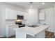 Bright kitchen with stainless steel appliances, white cabinets, and a large island at 18334 W Desert Hollow Dr, Wittmann, AZ 85361