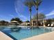 Inviting community pool with ample lounge chairs and shade structures for residents to relax and enjoy at 1893 S Sinova S Ave, Gilbert, AZ 85295