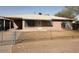 A single-story home featuring bars on the windows and a basic, fenced yard at 1950 E Wier Ave, Phoenix, AZ 85040