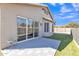 View of the backyard with gray patio tiles leading to sliding glass doors and manicured artificial grass at 20837 N 23Rd Pl, Phoenix, AZ 85024