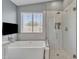 Modern bathroom with a large soaking tub, a tiled shower, and a window with blinds at 20837 N 23Rd Pl, Phoenix, AZ 85024