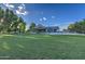 Expansive backyard featuring a covered patio, basketball court, and lush green lawn on a sunny day at 22406 S 173Rd Way, Gilbert, AZ 85298