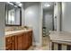 Bathroom with wood vanity, stone countertop, and open shelving at 22406 S 173Rd Way, Gilbert, AZ 85298