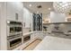 Bright kitchen with stainless steel appliances, white cabinets, and a stylish honeycomb pendant light at 22406 S 173Rd Way, Gilbert, AZ 85298