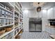 Organized pantry with ample storage, stainless refrigerator, and stylish black and white flooring at 22406 S 173Rd Way, Gilbert, AZ 85298