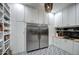 Well-stocked pantry with white cabinets, stainless refrigerator, and black and white patterned tile floors at 22406 S 173Rd Way, Gilbert, AZ 85298