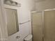 Bathroom with a shower, sliding glass door, mirror and toilet at 2423 E Flower St, Phoenix, AZ 85016