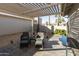 Relaxing covered patio with outdoor seating area and well-manicured landscaping at 25821 S Hollygreen Dr, Sun Lakes, AZ 85248