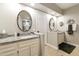 Bright bathroom with double vanities, oval mirrors, neutral paint, and tile flooring at 25821 S Hollygreen Dr, Sun Lakes, AZ 85248