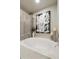 Relaxing soaking tub with elegant tile surround, modern art, and decorative accents at 25821 S Hollygreen Dr, Sun Lakes, AZ 85248