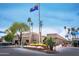 The community clubhouse with a flag, desert landscaping, and plenty of parking spaces at 25821 S Hollygreen Dr, Sun Lakes, AZ 85248