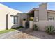 View of charming front entrance with desert landscaping, tiled pathway, and lovely potted plants at 25821 S Hollygreen Dr, Sun Lakes, AZ 85248