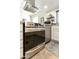 Close up of stainless steel oven and vent in bright kitchen with white cabinets and granite countertops at 25821 S Hollygreen Dr, Sun Lakes, AZ 85248