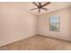 Neutral bedroom featuring a ceiling fan, a window, and plush carpeting at 25845 W Lynne Ln, Buckeye, AZ 85326