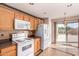 This kitchen has tile flooring, wood cabinets, white appliances, and a sliding glass door leading to the backyard at 25845 W Lynne Ln, Buckeye, AZ 85326