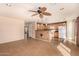 Open-concept living room with a ceiling fan, tiled floors, and access to the kitchen and other living spaces at 25845 W Lynne Ln, Buckeye, AZ 85326