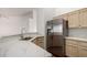 Corner of kitchen with granite countertop, stainless steel refrigerator, and light wood cabinets at 26632 S Branchwood Ct, Sun Lakes, AZ 85248