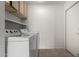 A functional laundry room features a washer, dryer, cabinet and adjacent door at 26632 S Branchwood Ct, Sun Lakes, AZ 85248