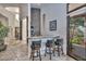 Stylish wet bar area with modern stools, mosaic wall decor, and views into the foyer at 28503 N 104Th Way, Scottsdale, AZ 85262