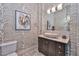 Chic powder room showcasing a unique leaf patterned wallpaper, vessel sink, and decorative mirror at 28503 N 104Th Way, Scottsdale, AZ 85262